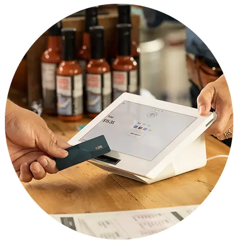 Canadian merchant accepting credit card payment on a modern POS terminal at retail checkout